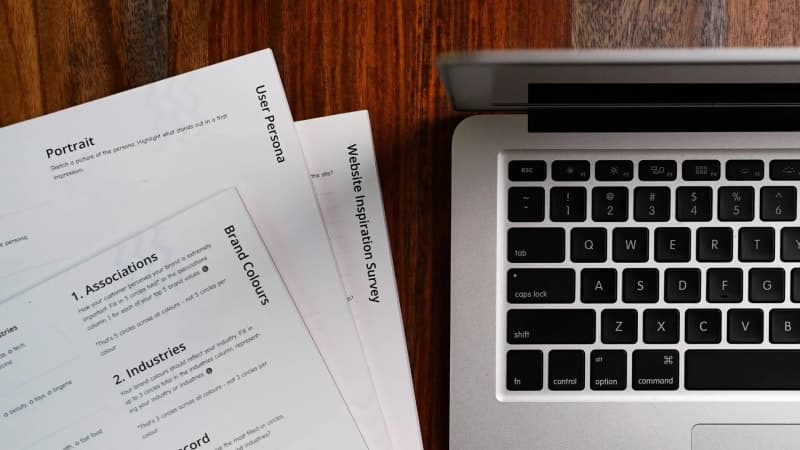 A polished, branded commercial cleaning proposal document laid open on a desk next to a laptop, showing a scope-of-work table.